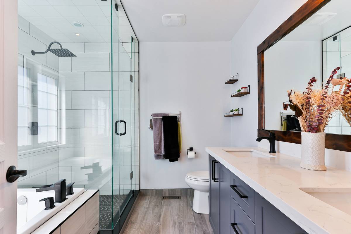 Diagram comparing clearance needed for swing door vs. bi-fold shower door in small bathroom layout