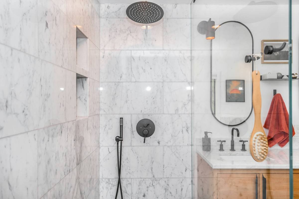 Diagram comparing swing clearance of hinged vs. bi-fold shower doors in small bathroom layouts
