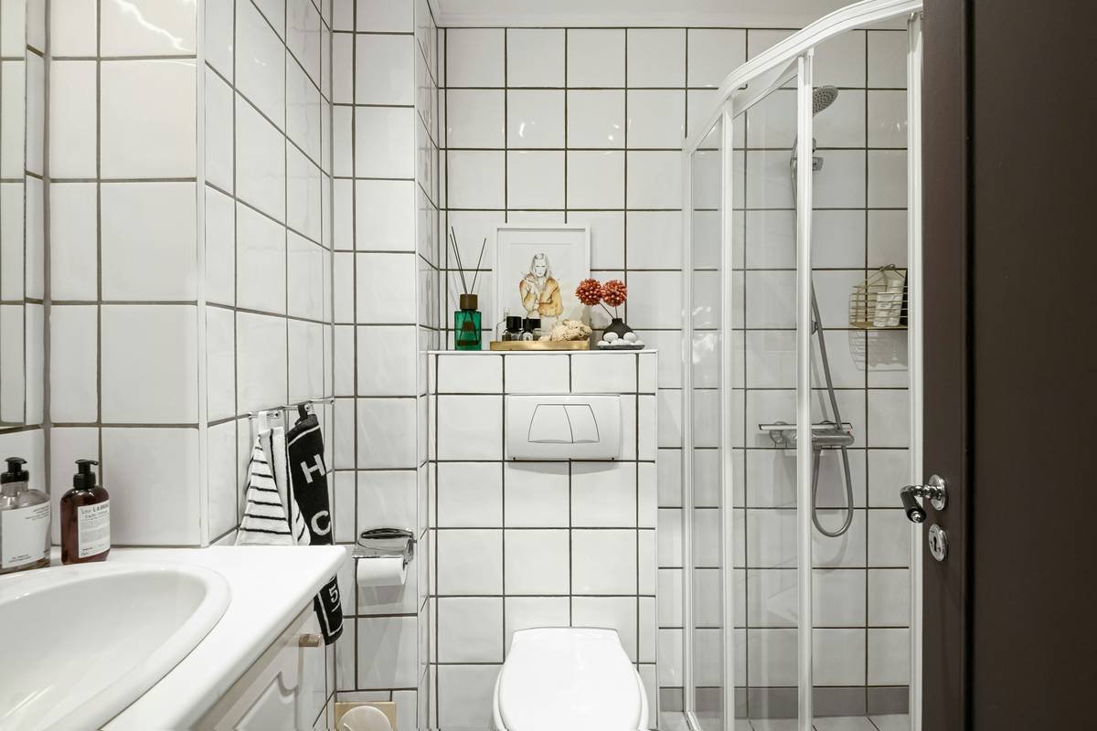 Diagram comparing swing radius of hinged vs. bi-fold shower doors in small bathrooms