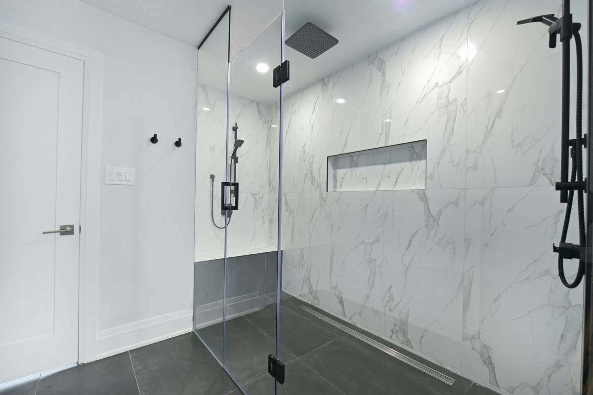 Diagram showing how an adjustable bi-fold shower door folds inward and adjusts width from 33 to 36 inches