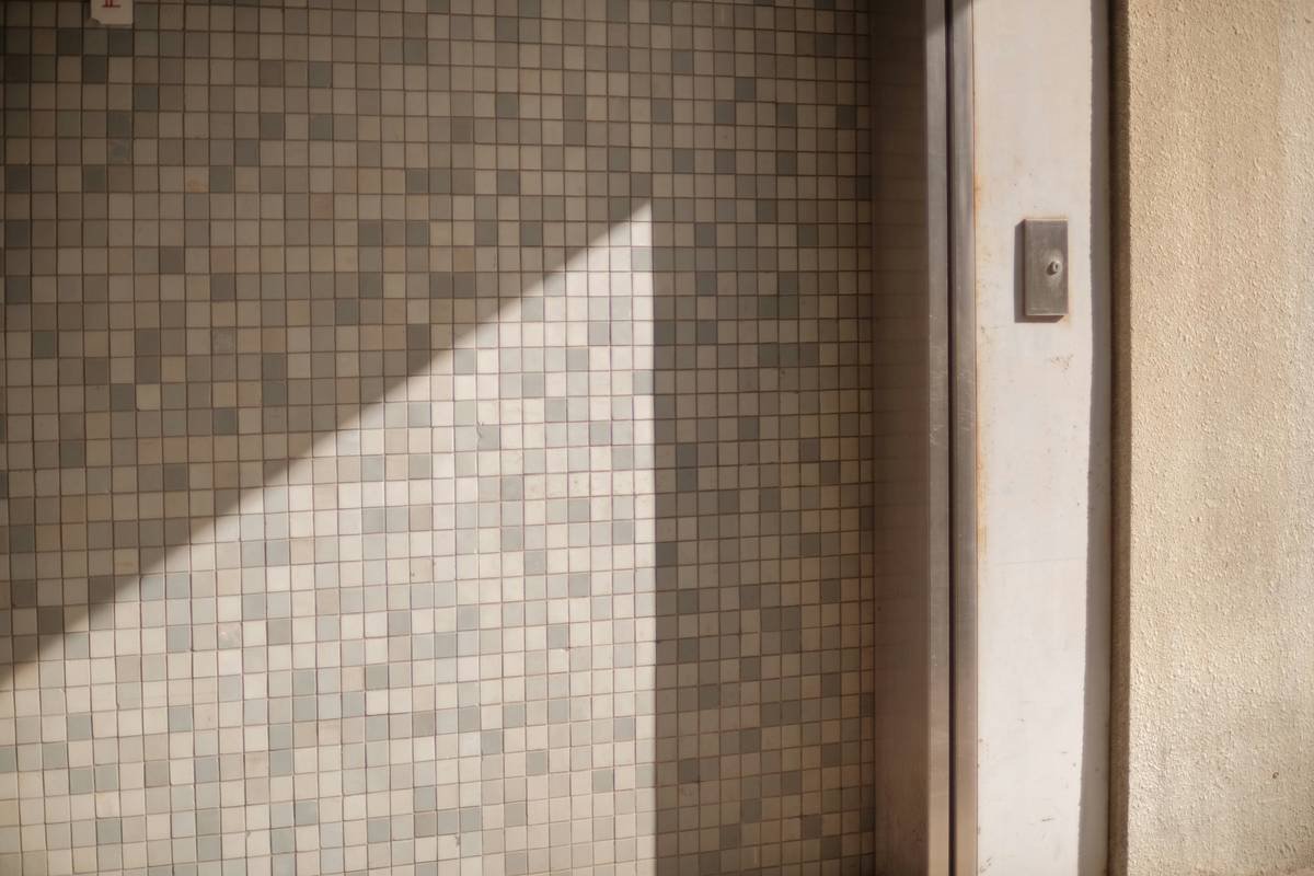 Close-up of bi-fold shower door hinges and seal in a space saving shower room showing waterproof integrity